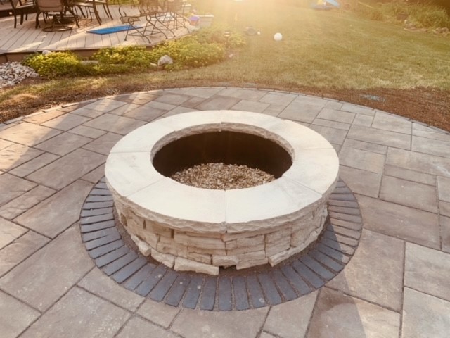 Outdoor stone fire pit with surrounding paver patio