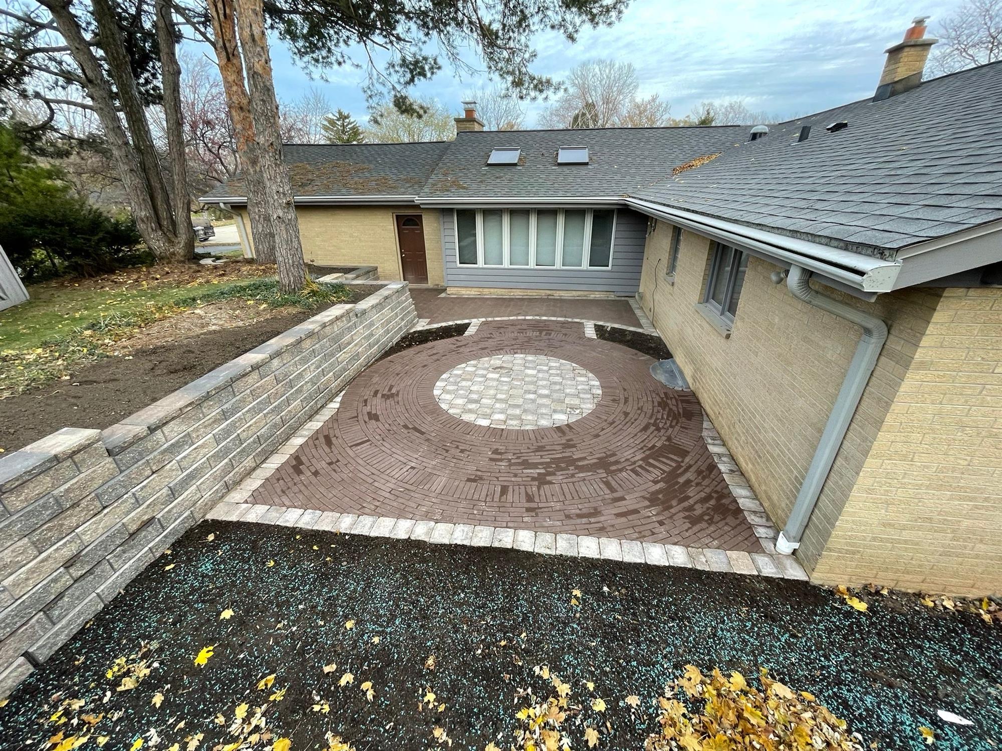 Backyard Patio with large Retaining Walls and Circular Brick Pattern