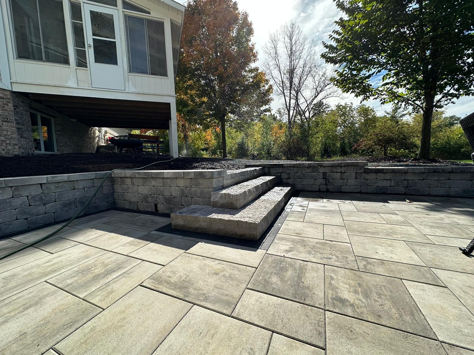 Backyard Patio with a Retaining Wall and Large Stone Steps