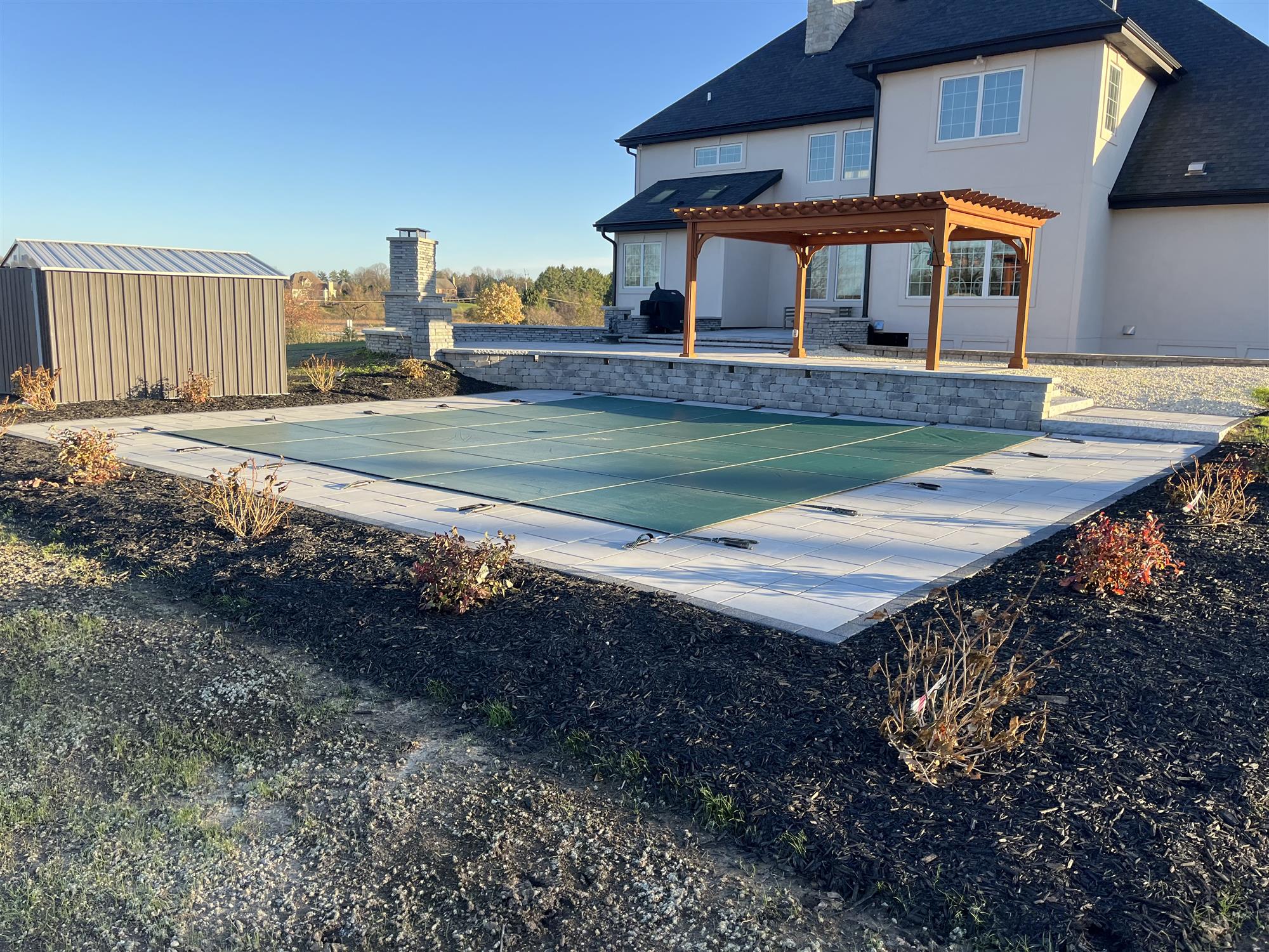 Back Patio with a Large Pergola, Retaining Walls, an Outdoor Kitchen, and a Small EcoPool