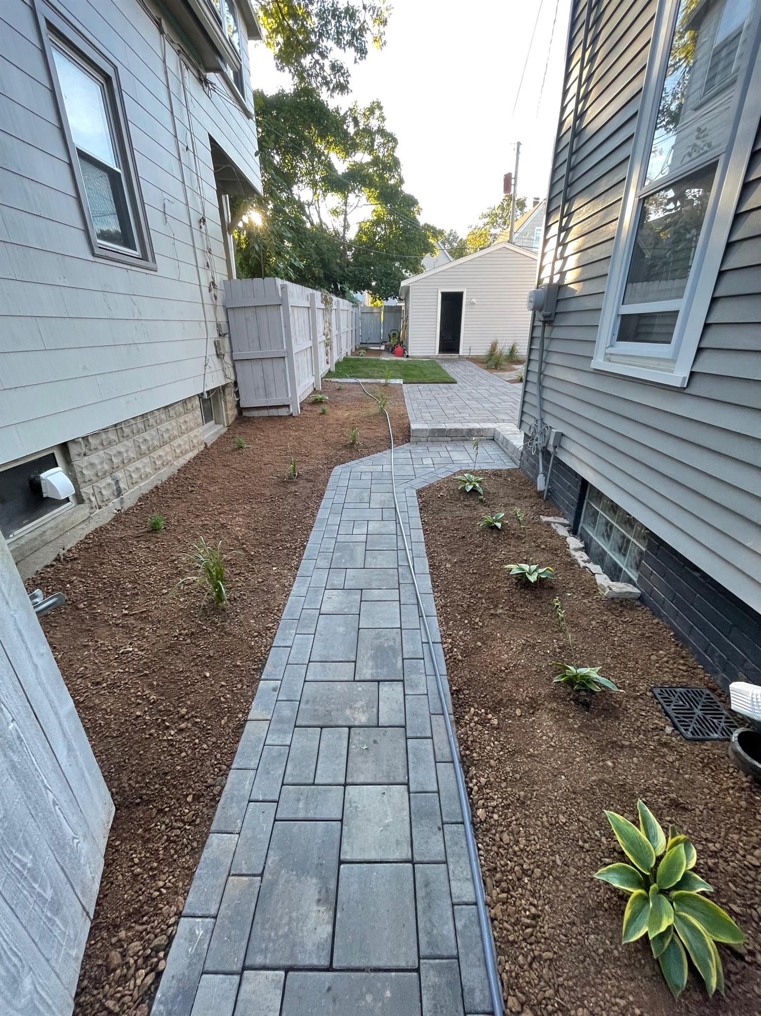 Stone patio walkway to backyard patio