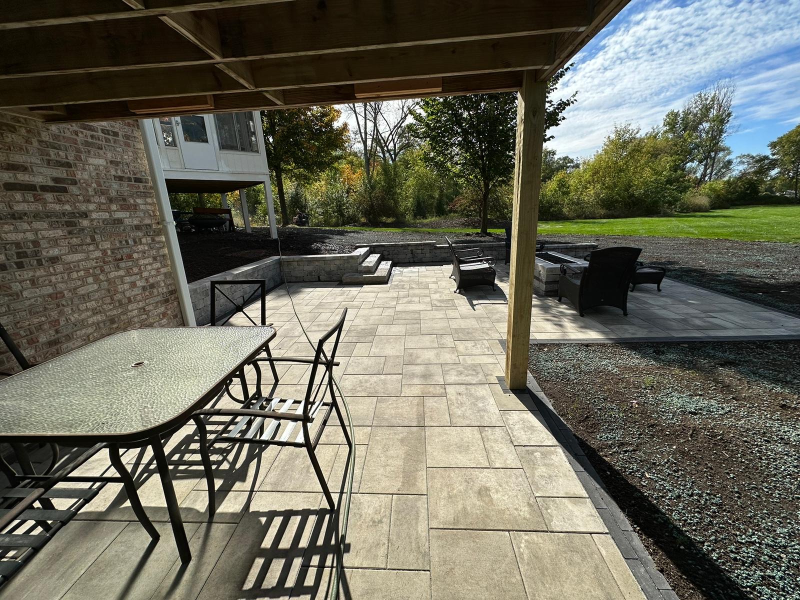 Patio with a Porch Partially Overhead and a Fireplace with Small Retaining Walls