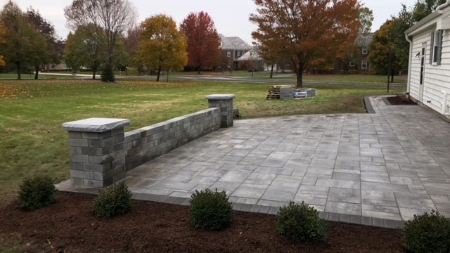 Gray stone paver patio with sitting wall