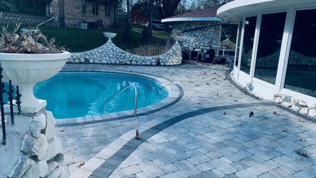 Stone wall surrounding stone paver patio