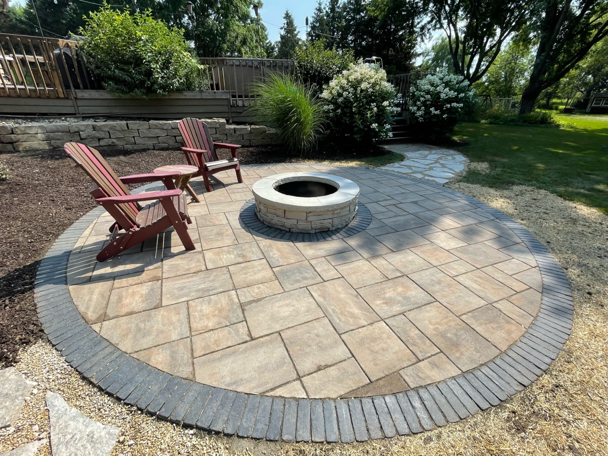 Circular patio with fire pit and stone walkway 